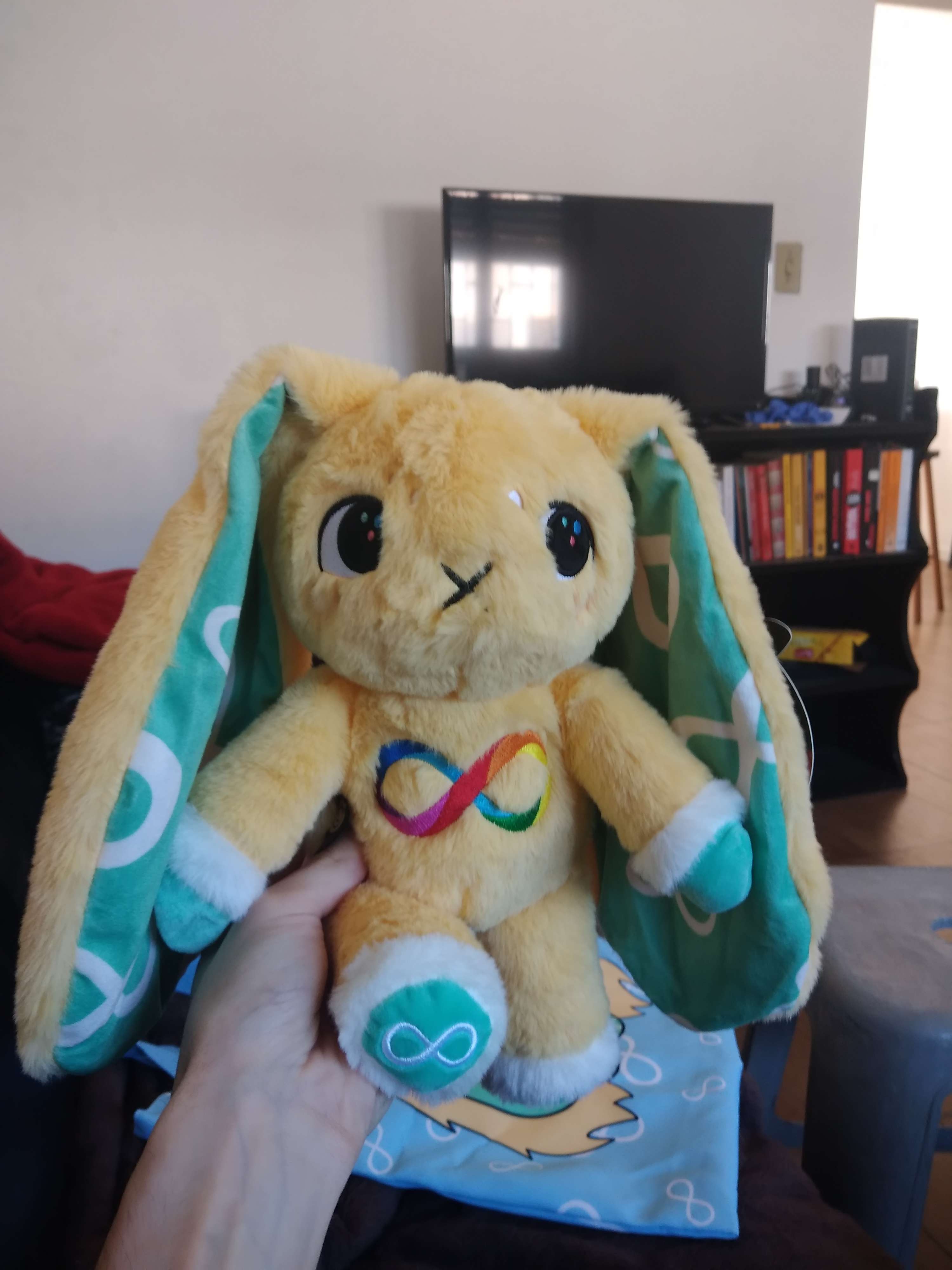 a rabbit plush with the symbol for autism on its belly