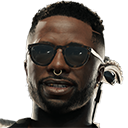 Man with a short haircut wearing dark sunglasses and a gold septum ring.