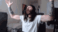 A man with long hair and a beard raises his arms in a triumphant victory gesture.