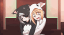 Two anime characters wearing black and white cat onesies hugging each other affectionately.