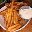 French fries in a bowl with a side of white dipping sauce.