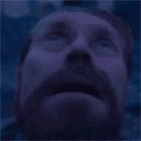Willem Dafoe looking up with a confused and distressed expression.