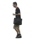 A man in a black shirt and khaki shorts walking while carrying a black bag.