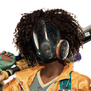 A person with curly hair wearing a black gas mask and a yellow jacket.