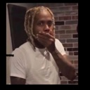 A man with blonde dreadlocks covers his mouth with his hand in a gesture of shock or surprise.
