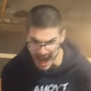 Man with glasses screaming with an intense, blurry facial expression.