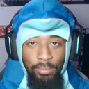 Man wearing a blue shark-themed hood looking directly into the camera with a neutral, deadpan expression.