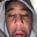 Person wearing a gray hoodie with a wide-eyed, stunned expression looking directly at the camera.