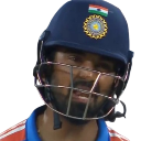 A cricket player wearing a blue helmet looking down with a sad and frustrated expression.