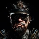 Soldier wearing a military cap and smoking a cigarette with a serious, shadowed expression.