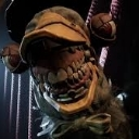 A close-up of a monstrous face with a wide, jagged, and unsettling grin full of sharp teeth.