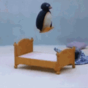 Pingu the penguin jumping repeatedly into a small wooden bed.