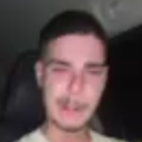 A blurry, low-resolution photo of a man looking distressed and overwhelmed.
