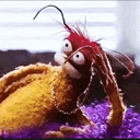 A fuzzy orange creature with wide, panicked eyes looking to the side against a purple background.
