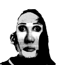 Human face with wide, hollow eyes and high-contrast lighting staring directly forward.