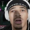 A man wearing headphones looking directly at the camera with a shocked and confused expression.