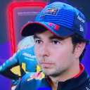 Sergio Perez wearing a blue racing cap with a serious and intense facial expression.
