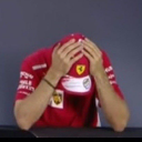 Person wearing a red cap with their head in their hands in a gesture of frustration.