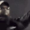 Person wearing a hat dancing and raising hands in a rhythmic motion.