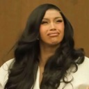 A woman with long dark hair making a skeptical and unimpressed facial expression.