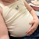A person rubbing their round, full belly with their hand.