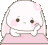 A white bunny with pink ears resting its head on its hand while leaning on a pink table.