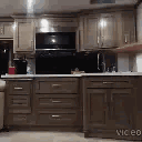 A person dancing energetically in a kitchen setting.
