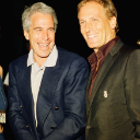Jeffrey Epstein smiling while wearing a suit in a photograph.