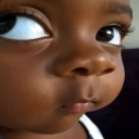 A toddler looking to the side with a skeptical and judgmental expression.
