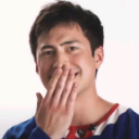 Man covering his mouth with his hand while laughing.