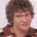 Man with curly hair making a skeptical side-eye expression.