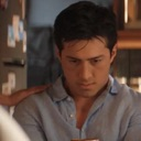 A man looking down with a skeptical, annoyed expression on his face.