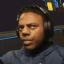 A man wearing headphones looking into the camera with a skeptical and unimpressed facial expression.