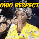IShowSpeed with hands pressed together in a prayer gesture wearing a yellow outfit with text reading OHIO RESPECT above him.