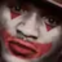 Clown face with white paint and red mouth markings looking directly at the camera.