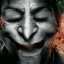 A close-up of a face with a wide, dark, and unsettling grin and closed eyes.