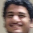 A person with a wide, blurry grin looking directly at the camera.
