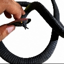 Hand holding a small black toy snake in a teasing motion.