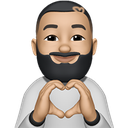 A man with a beard making a heart shape with his hands.