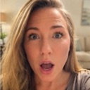 Woman with blonde hair looking directly at the camera with wide eyes and an open mouth in shock.