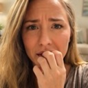 Woman biting her fingernails with a worried and anxious facial expression.