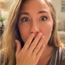 Woman with wide eyes covers her mouth with her hand in a gesture of shock.