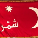 Red flag featuring a white crescent moon, an eight-pointed star, and Arabic text in the center.