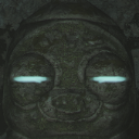 Stone statue face with glowing blue eyes staring forward intensely.