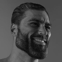 Man with an extremely defined jawline and beard smiling confidently in a black and white portrait.