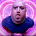 A bald man with a distorted face sticking his tongue out in front of a pink and purple heart background.