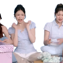 A woman with a wide-eyed shocked expression and hands raised near her face.