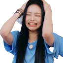 A young woman with long black hair wearing a blue t-shirt clutching her head with both hands while making a pained, stressed…