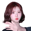 A young woman with reddish-brown hair posing with her hand near her chin.