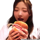A girl with eyes closed taking a large bite of a burger.